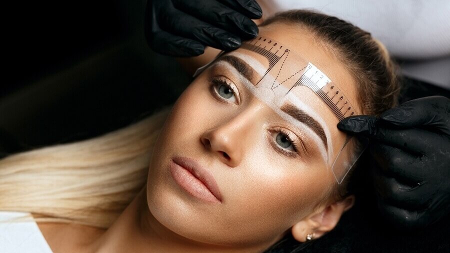 permanent makeup artist giving client an eyebrow treatment