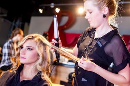 Destinee styling a model's hair at an event