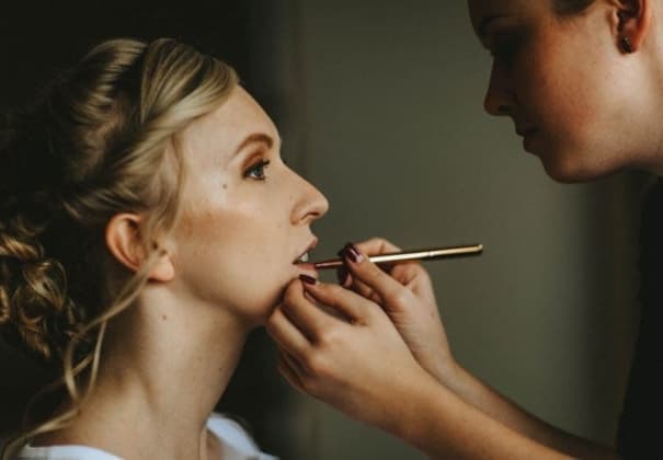 Makeup artist Destinee Cushing applying prom makeup to a young lady