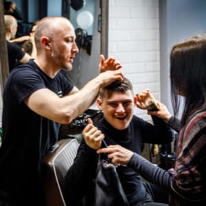 cosmetologist giving a disabled man a haircut