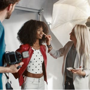 Makeup artist applying foundation to a model at a photoshoot