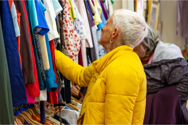 Elderly woman looking at clothes on a rack