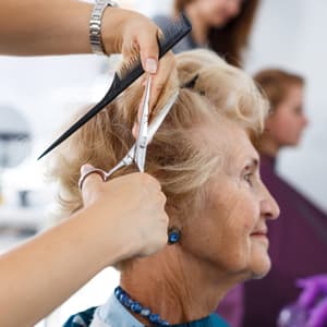 cosmetologist giving an elderly woman a haircut