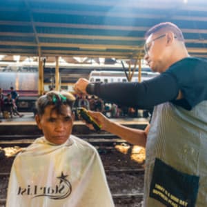 barber giving a homeless man a haircut