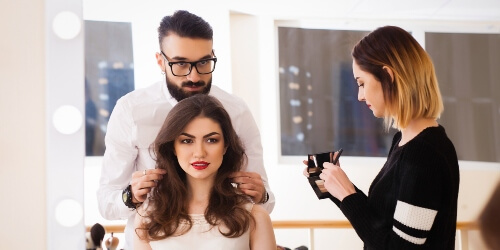 cosmetologists styling a client