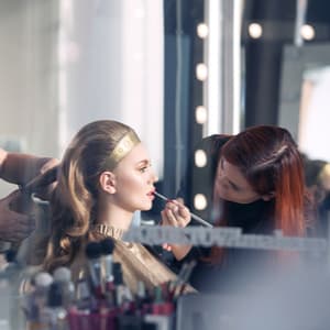 Makeup Artist applying lipstick to a woman