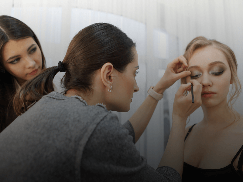 teacher showing students how to apply makeup