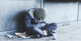 homeless person sitting on the street